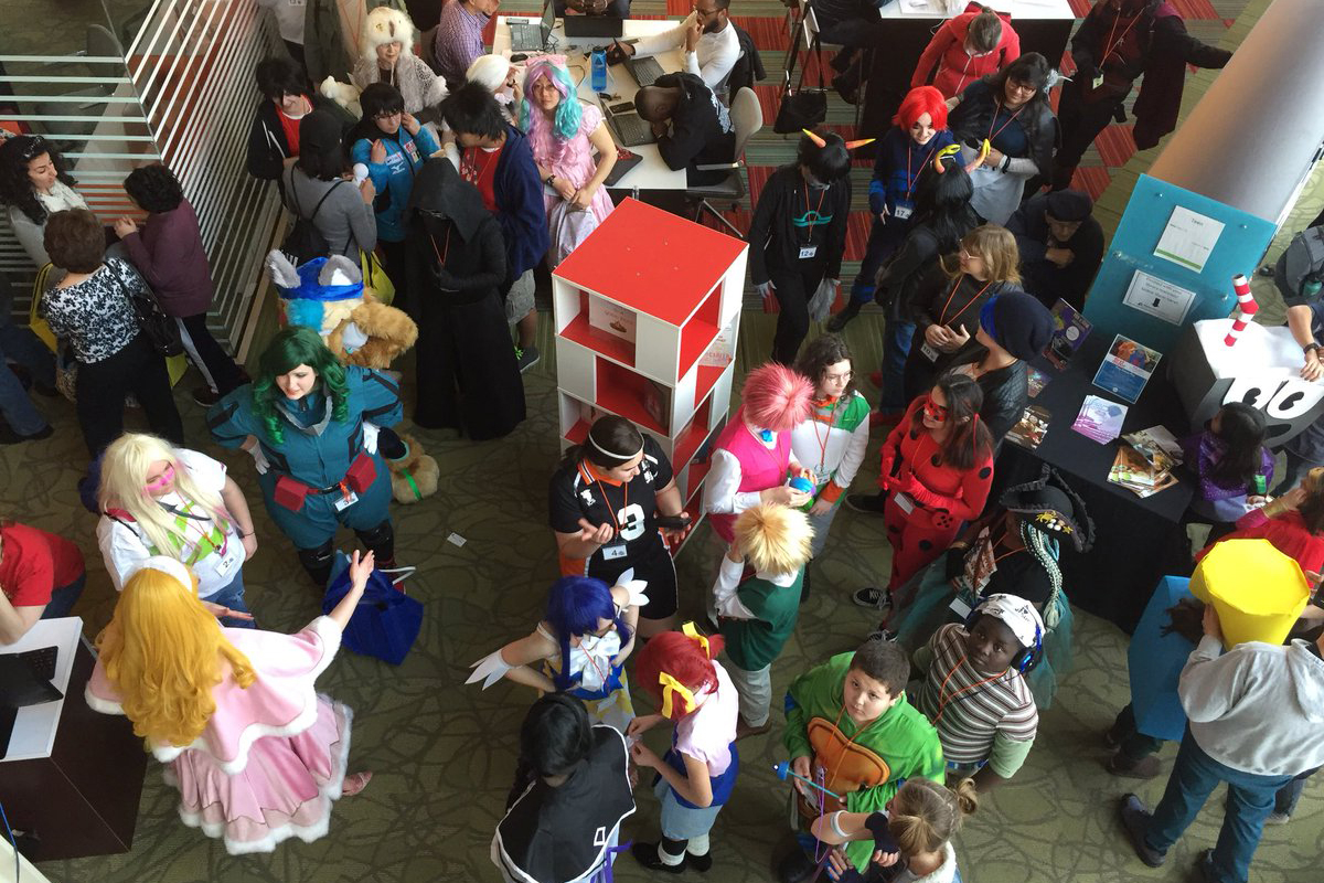 People in colorful character costumes mingle at an event.