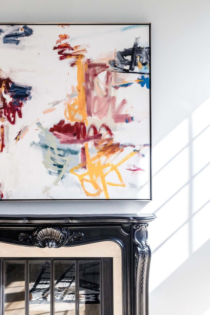 Modern art with splashed, streaky colors over a fireplace