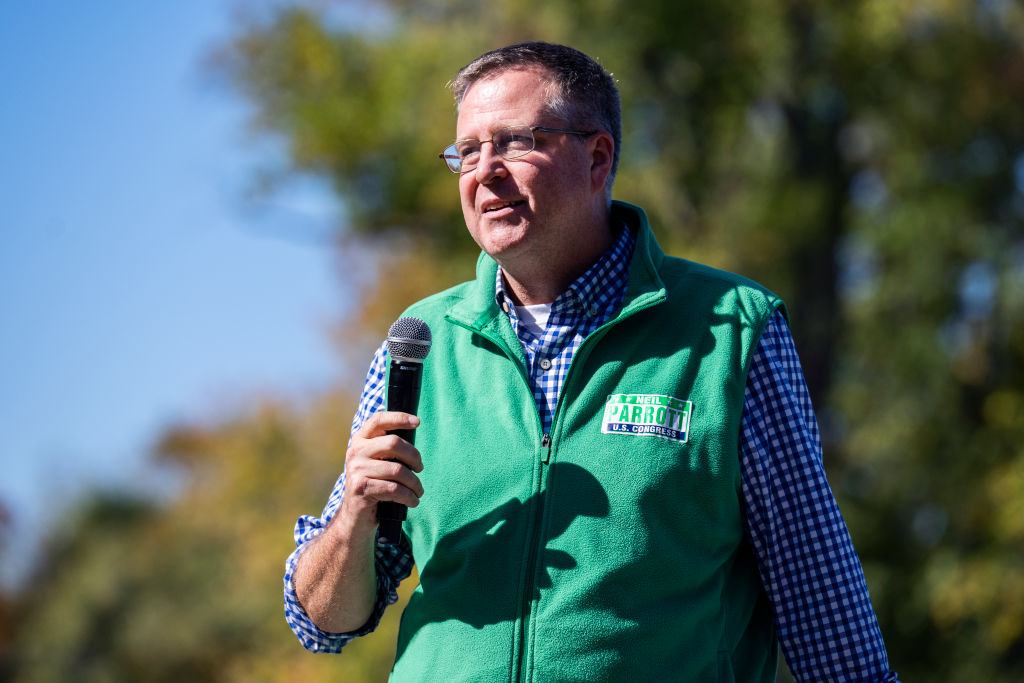 A man in a green vest holding a microphone