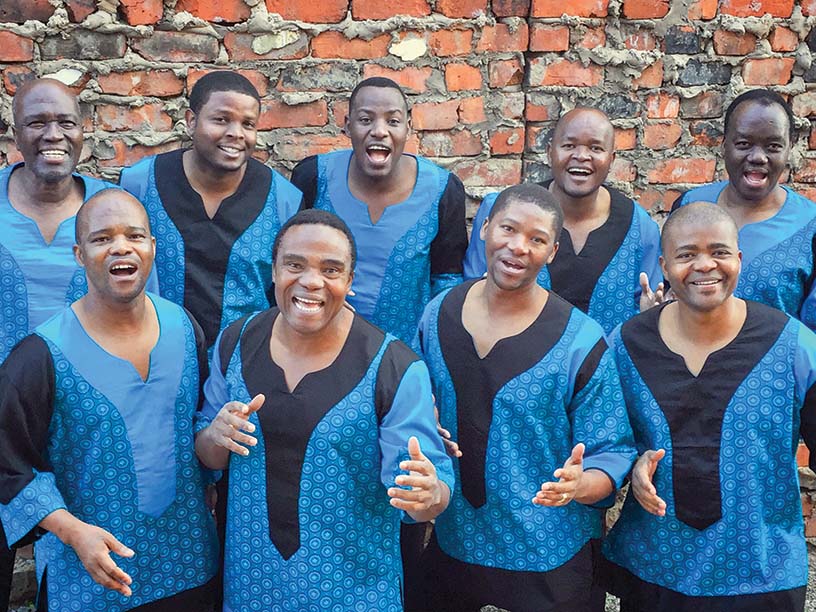 A group of singers in blue and black matching outfits