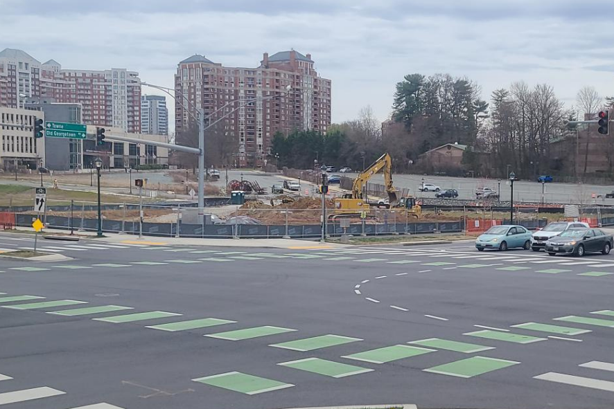 Photo of an three-lane intersection with a construction site in the distance building The Pinnacle.